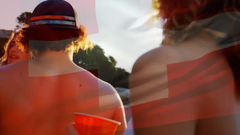 animation of flag of switzerland over diverse friends dancing and drinking a toast on sunny beach