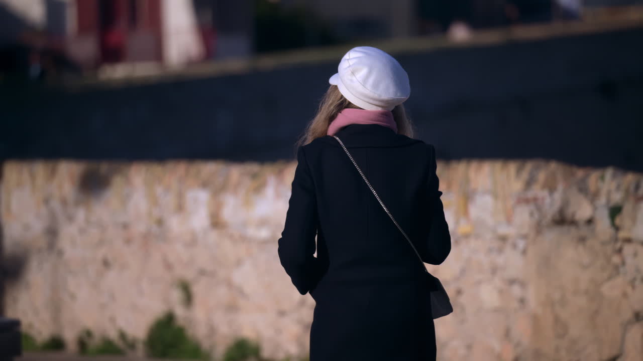 Woman wearing a coat, walking on the street in Cannes, France