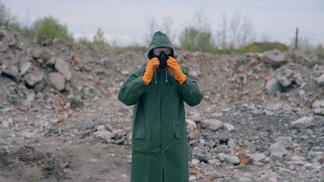 ecologist in safety suit on ruined building background. person in gas mask and protective clothes stands in dangerous place after chemical attack