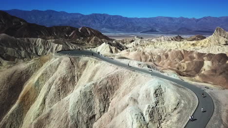 people walking to the lookout over zabriskie point in death valley national park, aerial flyover