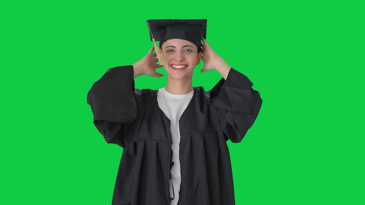 Ragazza indiana universitaria felice che si prepara per la cerimonia di laurea Green screen