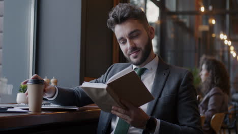 businessman reading and drinking coffee in a cafe