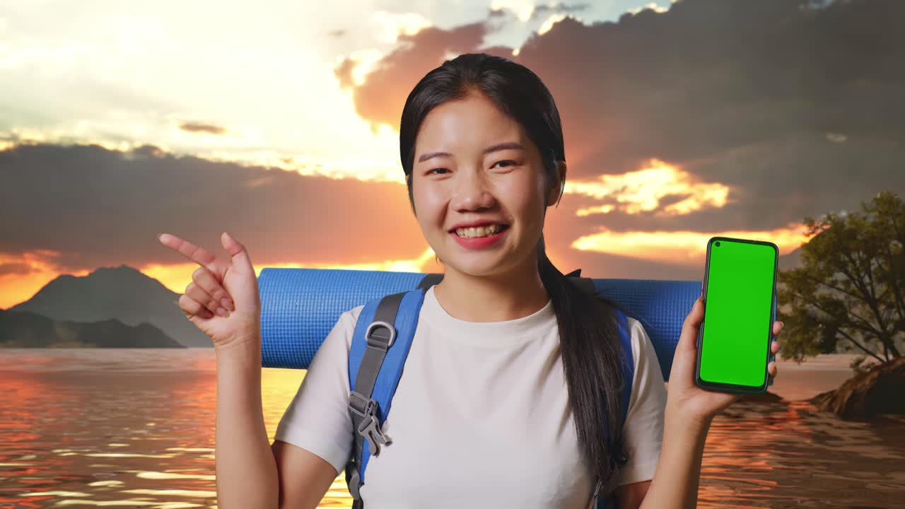 счастливый путешественник с зеленым экраном телефона на закате