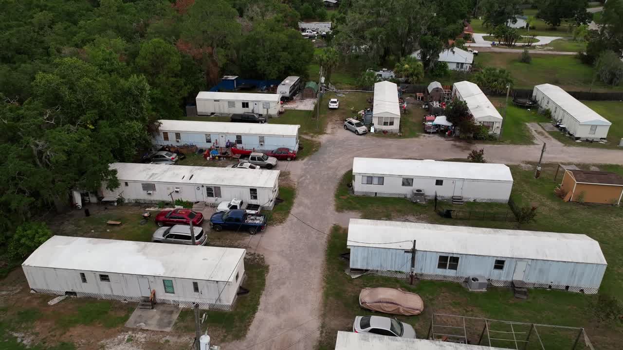 Rusty Mobile trailer homes in Florida, United States. Aerial rising shot of cheap, affordable housing in America. Cheap low income housing area of Brandon, FL, USA. CLoudy day in summer. Parking cars