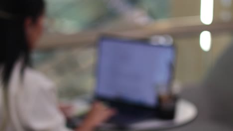 mujer centrada en la computadora portátil en un café