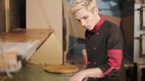 chef de pizza preparando pizza en la cocina de un restaurante