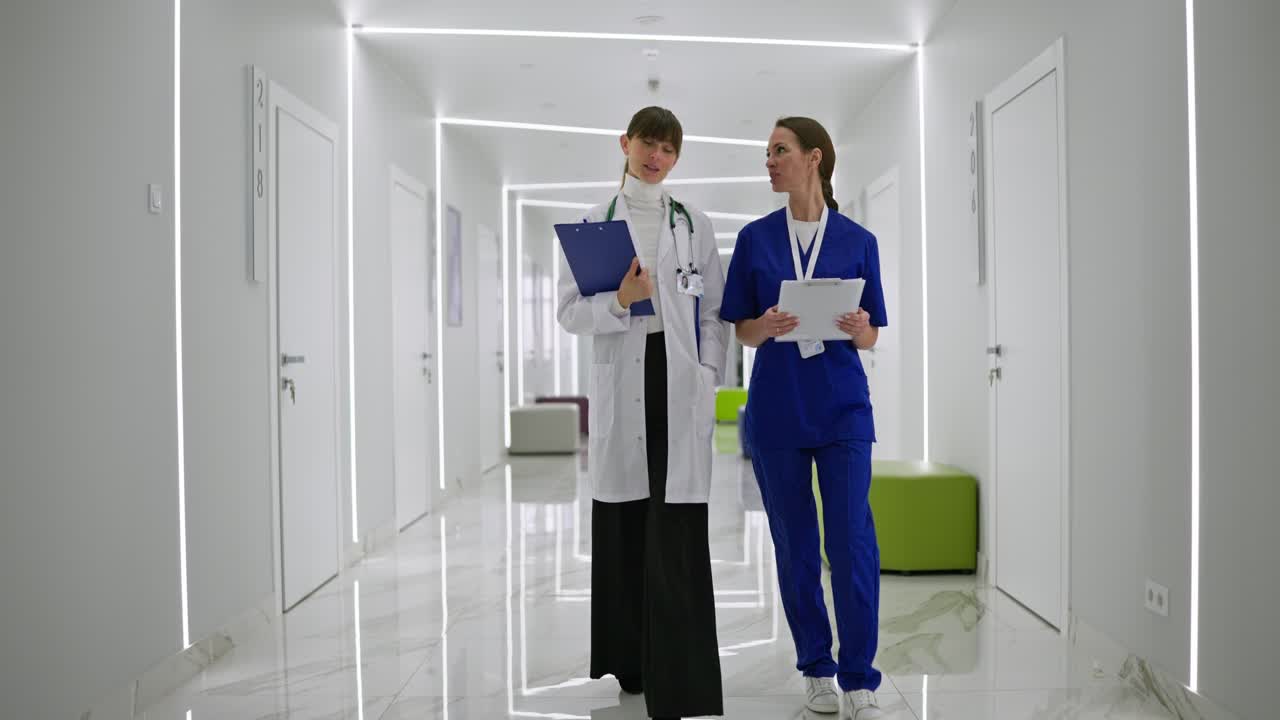 Dois Profissionais de Saúde Conversando em Corredor de Hospital