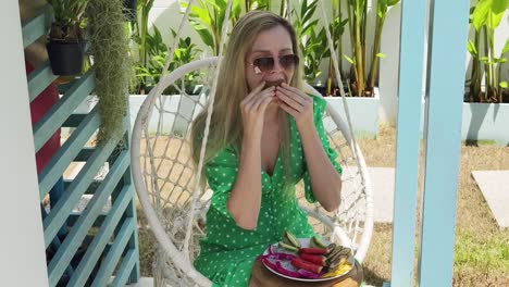 woman enjoying a fruit platter in a hanging chair