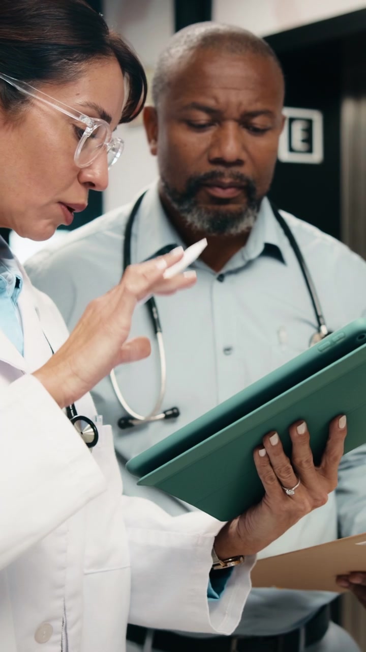 Operatori sanitari che discutono i dati del paziente su tablet digitale