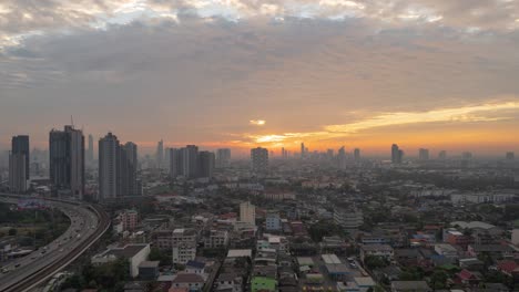 time lapse of aerial view of highway street road at bangkok downtown skyline, thailand. financial district and business centers in smart urban city in asia.skyscraper and high-rise buildings at sunset