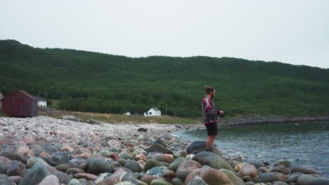 Man-Fishing-in-A-River-with-Rocks-and-Background-of-Green-Mountain