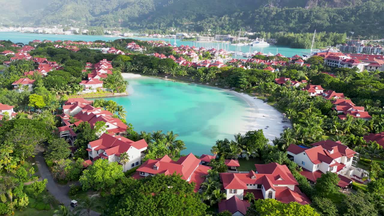 Aerial View of a Tropical Resort Island with Turquoise Bay and Red-Roofed Villas