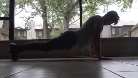 man doing pushups in morning at home on back porch