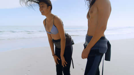 una pareja de surfistas disfrutando en la playa 4k