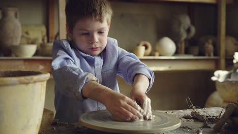 young boy learning pottery