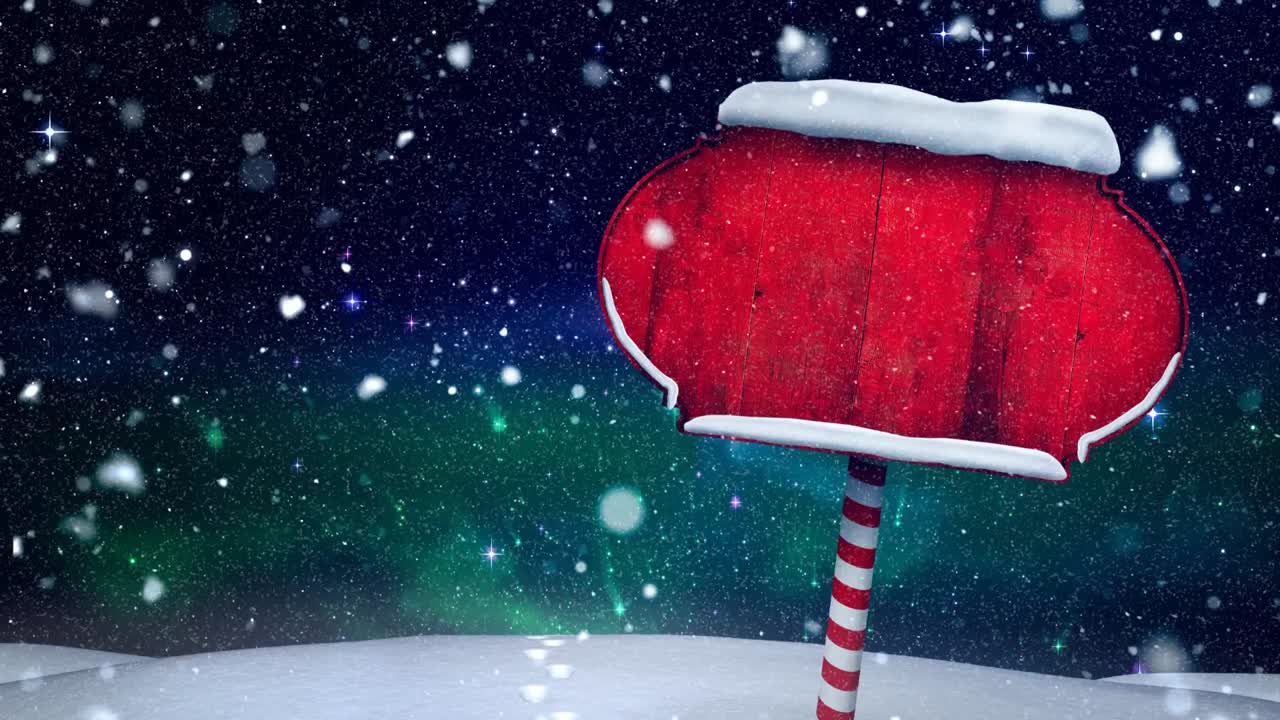 Snow falling over red wooden sign post on winter landscape against night sky