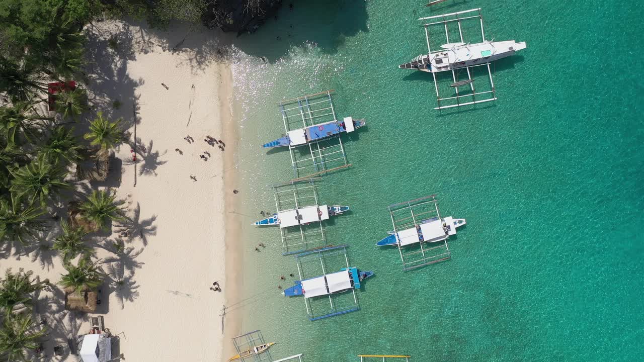 Drone flight over El Nido in the Philippines beaches and limestone cliffs, showing longtail boats, emerald green sea, clear waters, amazing beaches