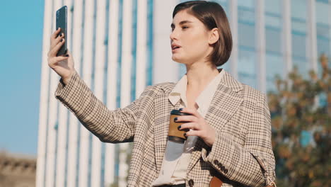 mujer elegante usando un teléfono inteligente al aire libre.