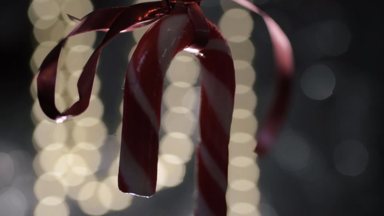 Single candy cane swinging with bokeh background close up shot