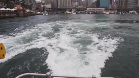 boat wake waves from back of boat leaving metropolitan city harbour slow motion