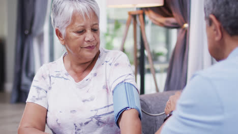 Senior-diverse-couple-sitting-and-measuring-blood-pressure