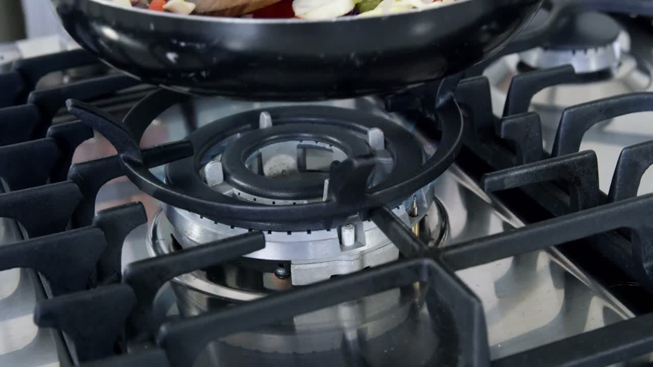 Frying pan getting put on gas cooker