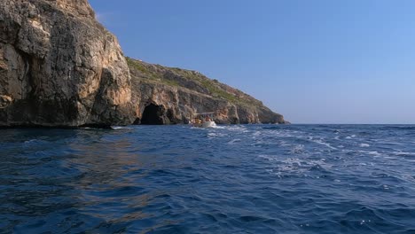 lancha navega a lo largo de la costa de punta meliso donde se encuentran los mares jónico y adriático