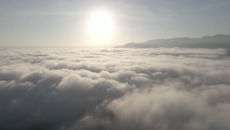 Drone-fly-backward-from-the-sun-with-ocean-of-cloud-below