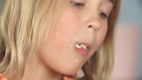 un primer plano de una chica comiendo un paquete de papas fritas