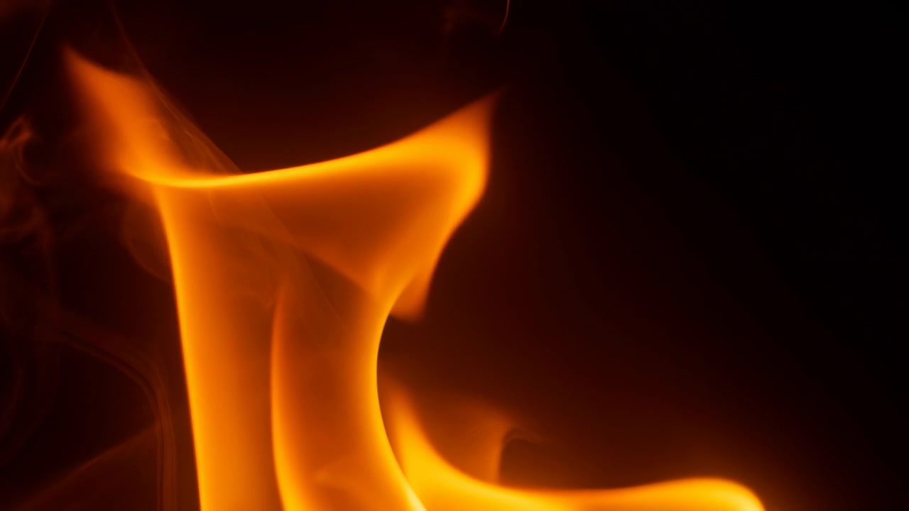 dynamic side view of intense flames burning in a dark background, vivid orange and yellow colors, dramatic mood, commercial promotional content with clean copy space for design and resource.