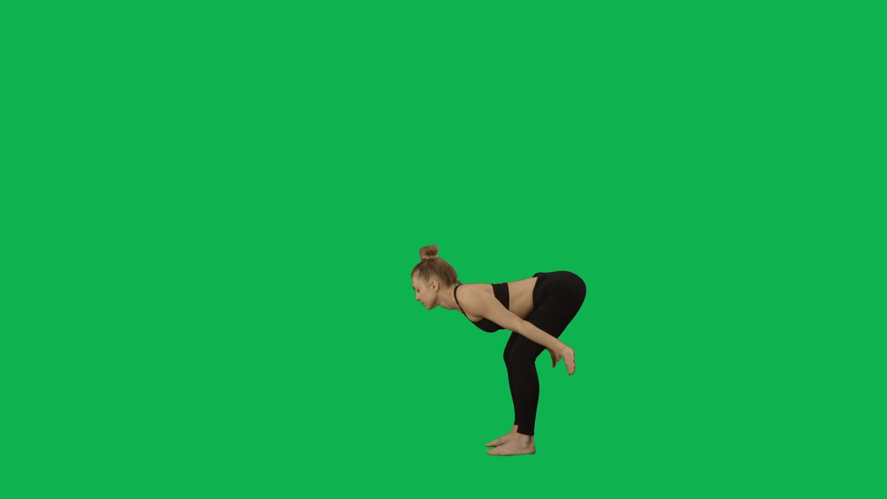 Jovem mulher em roupa esportiva praticando yoga, alongando o corpo. Treino, fitness feminino, aeróbica. Vista lateral de corpo inteiro em fundo de tela verde. Pronto para câmera lenta 59.94fps.