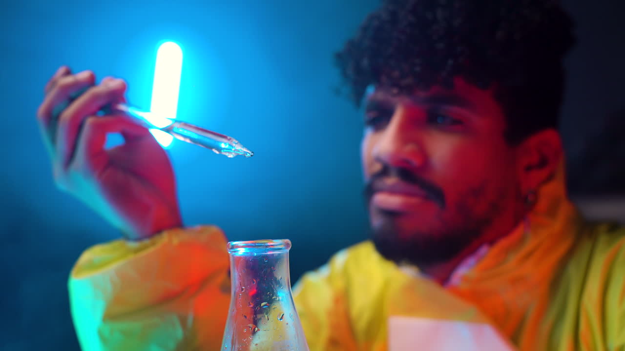 hispano dejando caer líquido transparente en el tubo de laboratorio, enfoque químico afro concentrado de cerca trabajando en laboratorio experimentando y estudiando solo