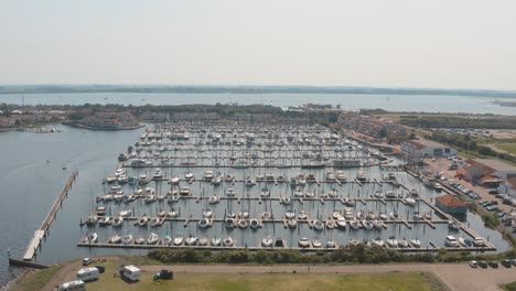 Cinematic-drone---aerial-panorama-circling-shot-of-a-marina---port-with-sailing-boats-on-a-sunny-day-at-Zeeland-at-the-north-sea,-Netherlands,-30p