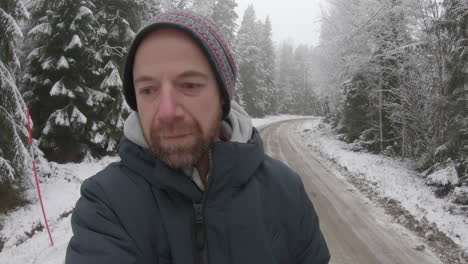 reteniendo las lágrimas, un hombre muy infeliz camina solo por un camino nevado