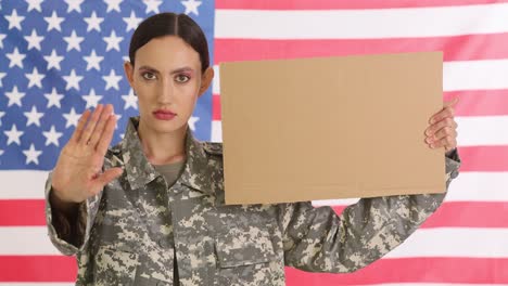 woman in military uniform holding a blank sign with an american flag background