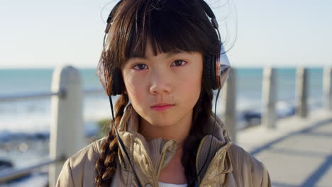 girl child, face and headphones at beach