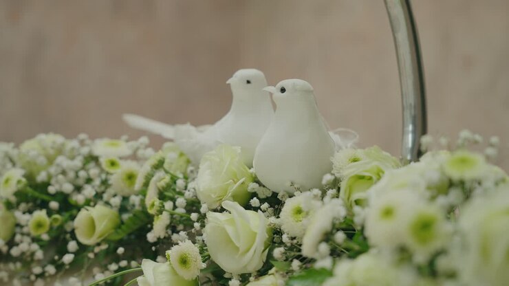 Fine hvide duer blandt bløde bryllupsblomster