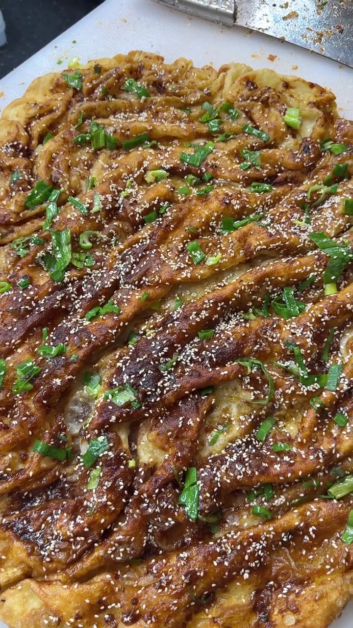 Freshly Cooked Savory Scallion Pancake Topped with Sauce and Sesame Seeds