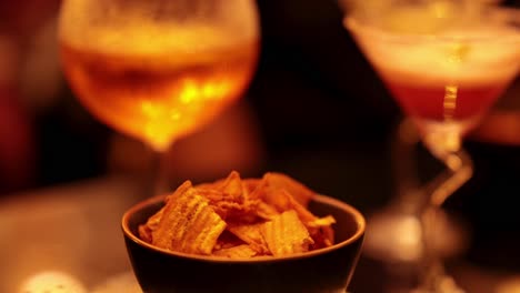 chips and cocktails in a dimly lit bar