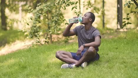 man drinking water in a park