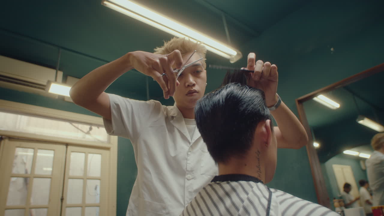 Asian Barber Thinning Hair of Client in the Barbershop