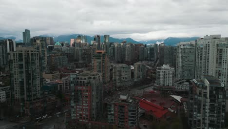 drone shot over david lam park revealing vancouver city skyline and the mountains in the background on an overcast day during spring