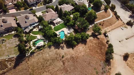 aerial top down of tracks in sandy desert mountains of california and luxury villas in suburbia. modern new developed residential area with mansions and swimming pools in garden. usa, la.