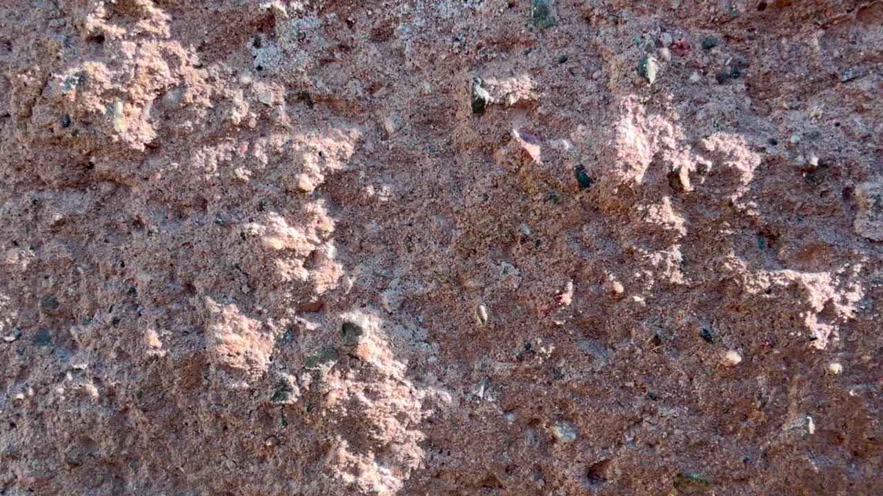 The rough surface of a wall can be seen, panning shot