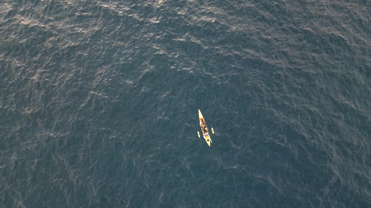 kayak amarillo está pescando en medio del océano