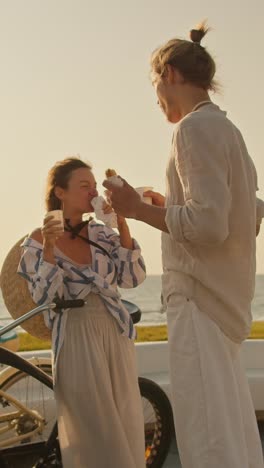 couple enjoying a snack by the beach