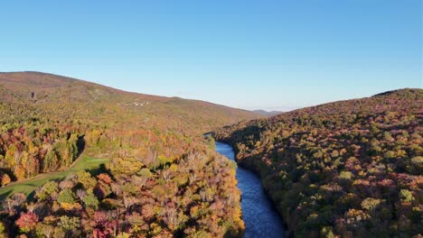 drone shot in autumn, we see a river and golf course. perfect shot ascending.