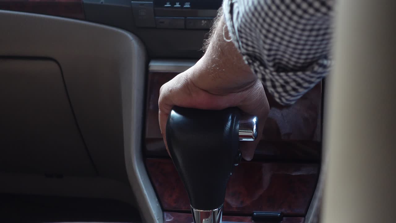 Hand on gear shift in a car