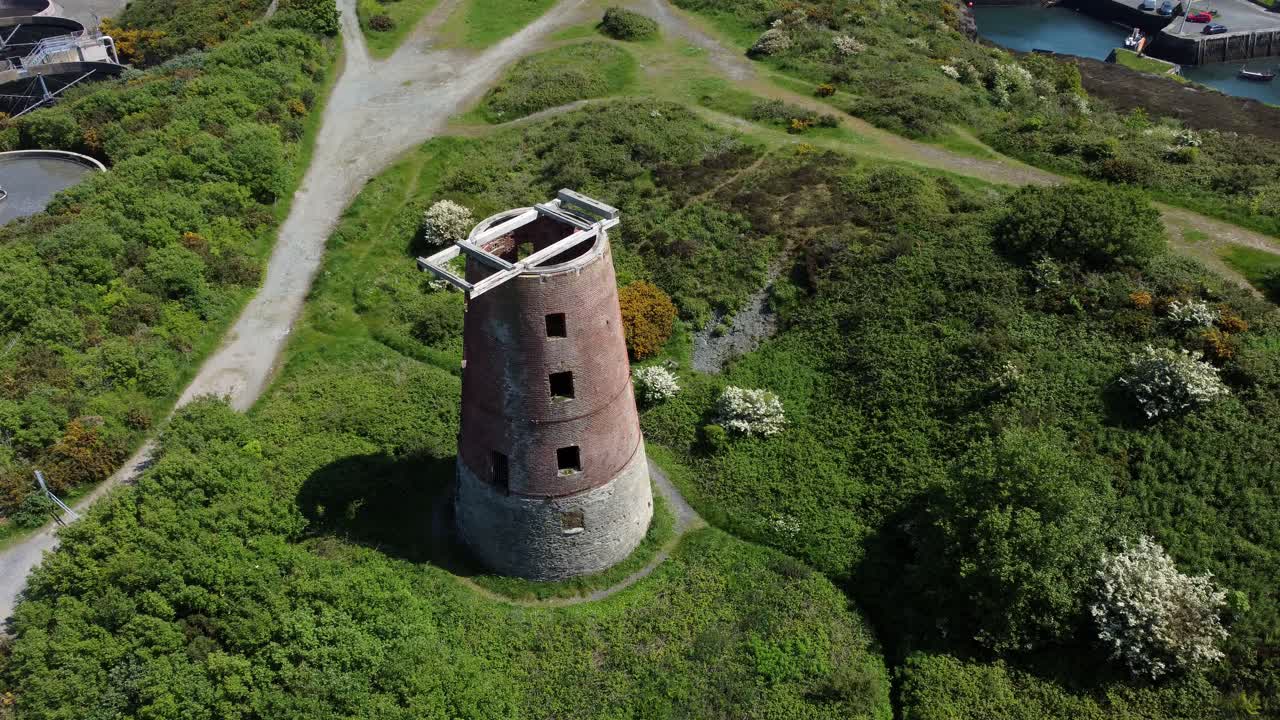 Amlwch port rderelict ed brick disused abandoned windmill aerial rising view North Anglesey Wales