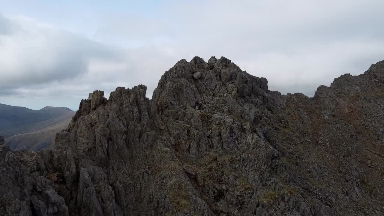 케이프타운에서 가장 유명한 여행 목적지 중 하나인 웅장하고 화려한 바위 테이블 마운틴 꼭대기에 서있는 커플의 드론 영상